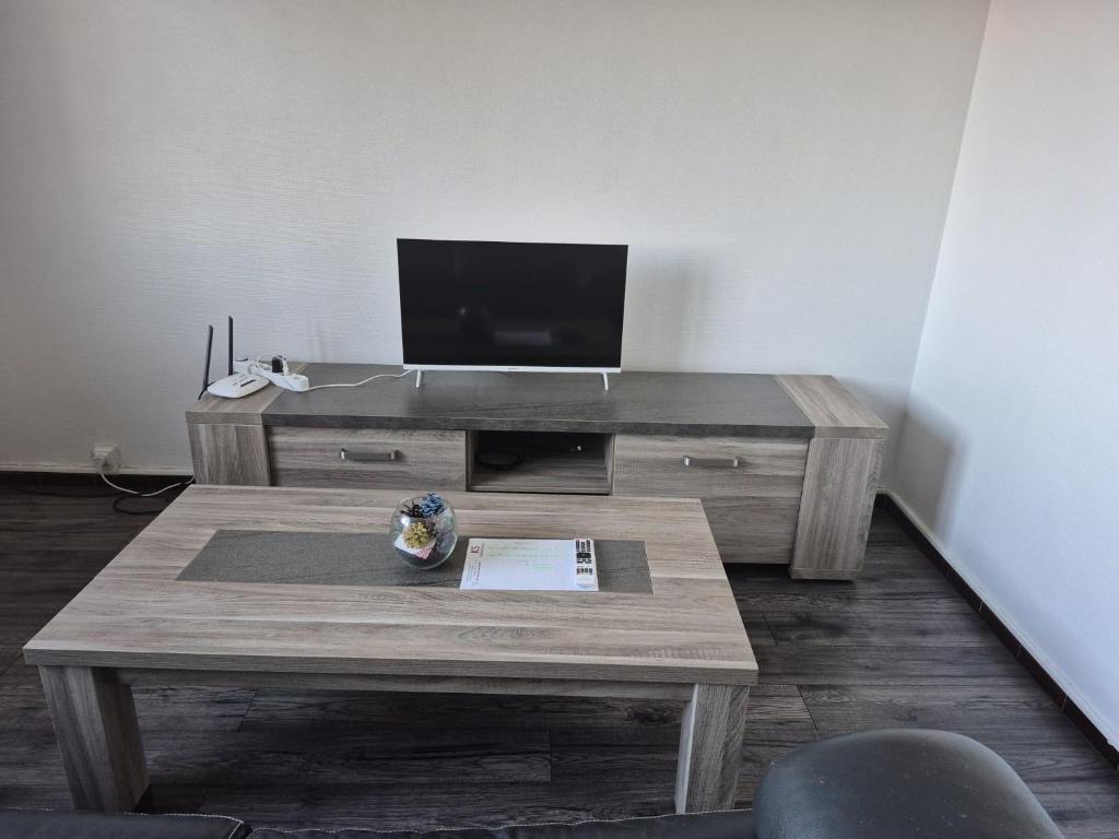 DiémozにあるBien proche de Aeroport St Exupéry Village de Marques et Lyonのリビングルーム(テレビ、木製テーブル付)