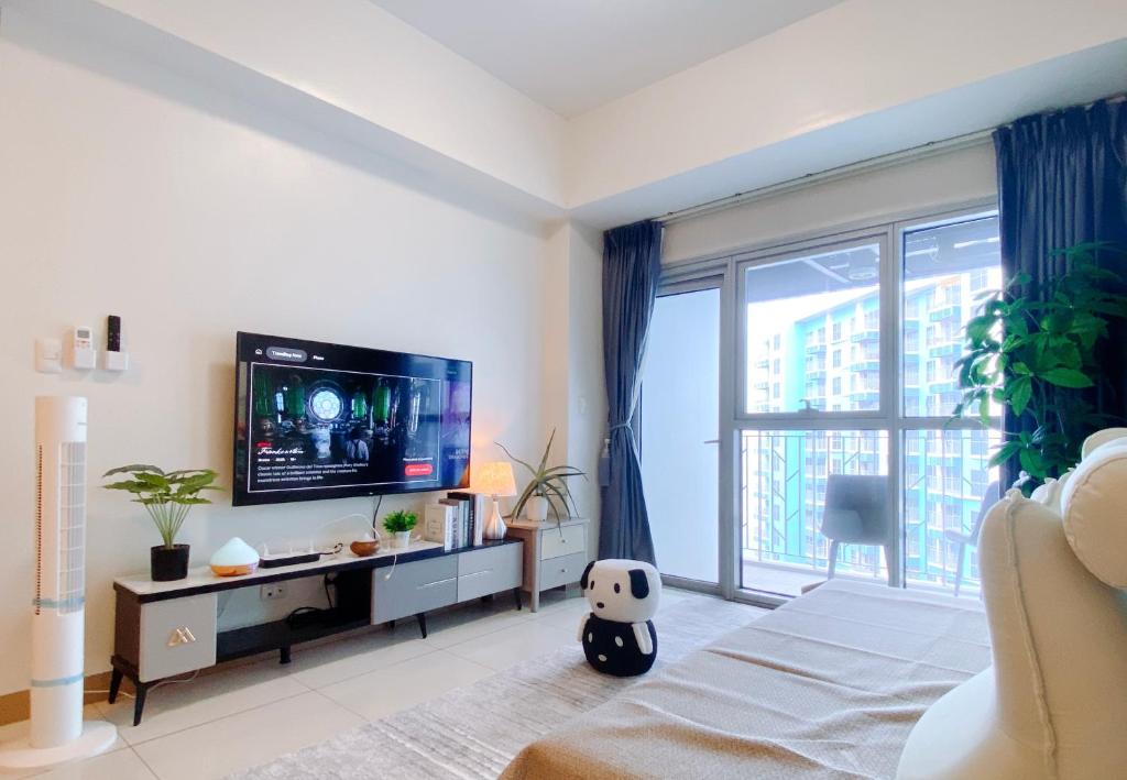 130 Sqm Luxurious Modern 3 Bedrooms Facing Manila Bay Sunset, Airports, Okada, Solaire, MOA with Free Parking في مانيلا: غرفة نوم مع تلفزيون ونافذة كبيرة