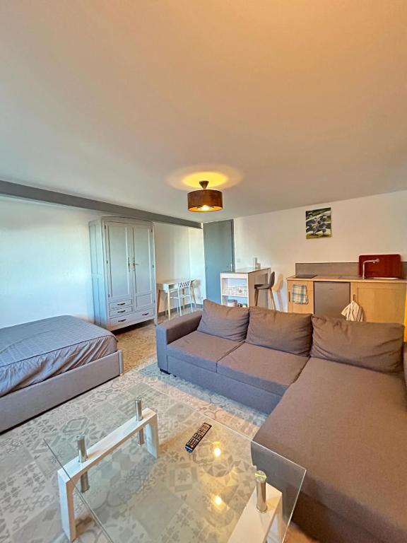 a living room with a couch and a bed at T1 a loué centre ville de Guéret in Guéret