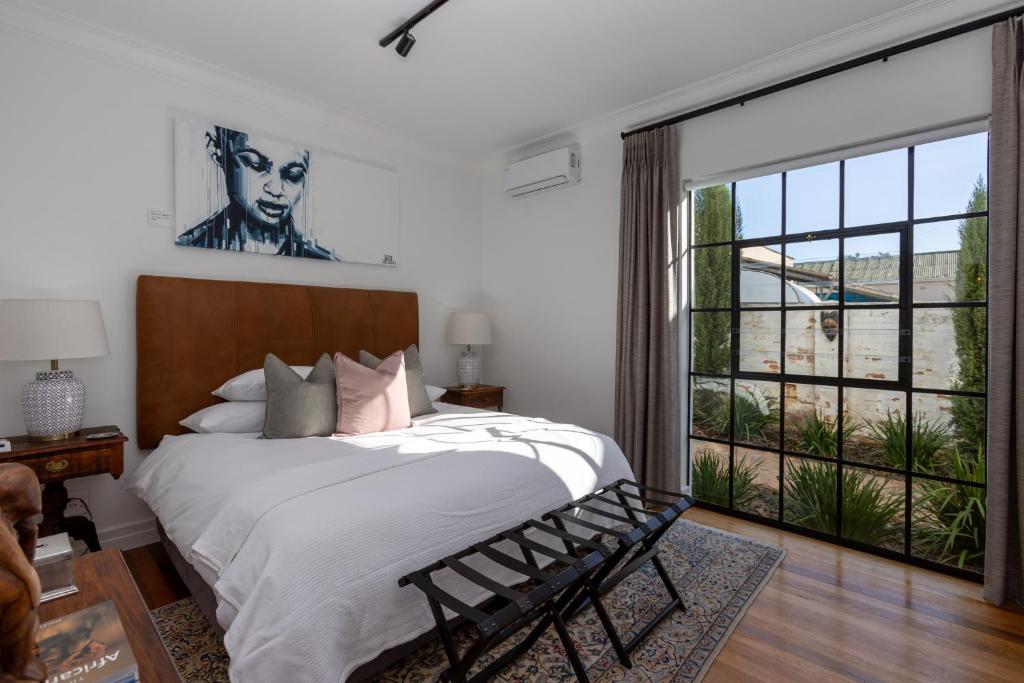 En eller flere senge i et værelse på La Maison On Main Self-Catering Villa