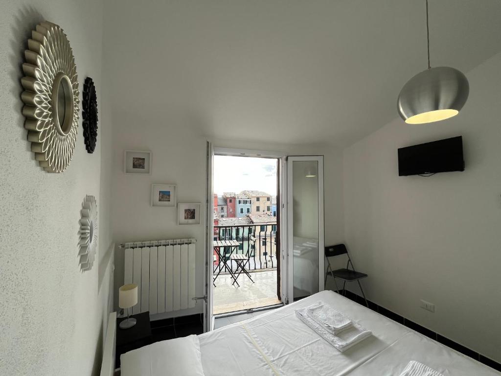 ヴェルナッツァにあるOld Town Roomsの白いベッドルーム(ベッド1台、バルコニー付)