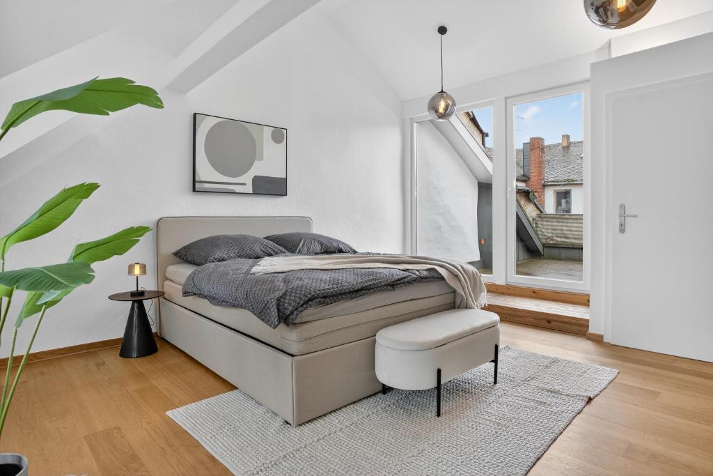 a white bedroom with a bed and a stool at 3 Queen Beds Waterfall Garage Terrace Center in Saarburg