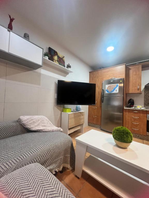 a room with a bed and a kitchen with a tv at Casa mis Nietas in San José