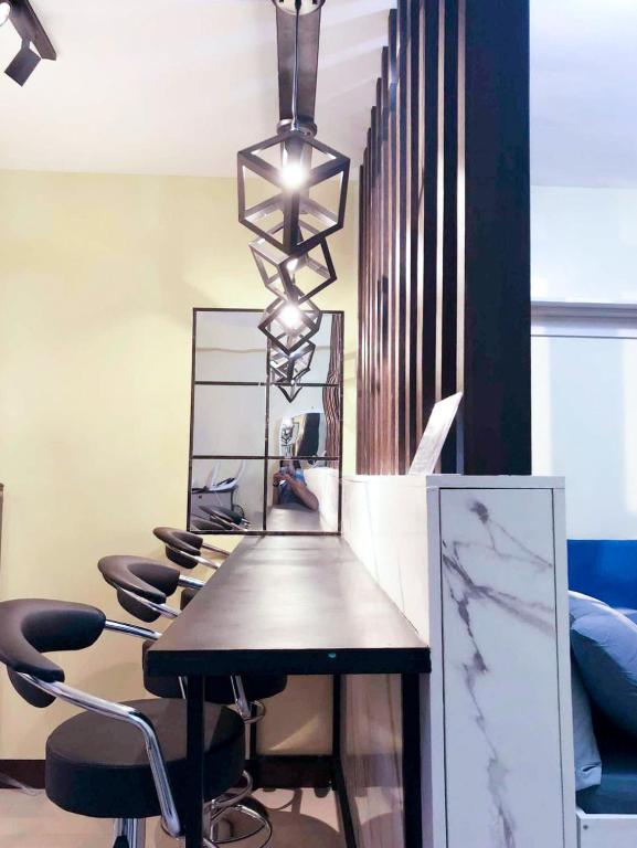 a room with a table with chairs and a mirror at Meraki Space Mactan Cebu in Lo-oc