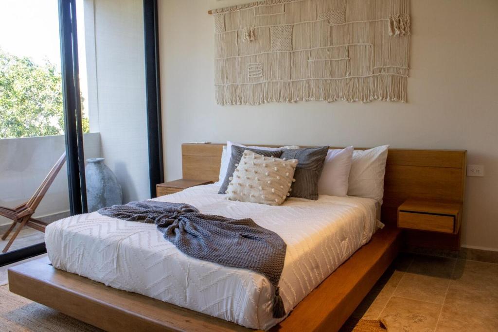 图卢姆Peregrina Tulum 301B 1BR Condo的卧室里有一张带木质床头板的床