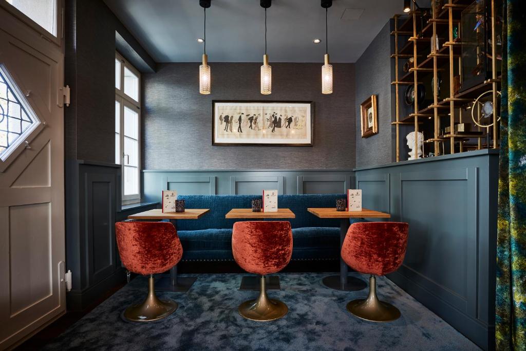 a restaurant with two tables and red chairs at Boutique Hotel Spedition a member of DESIGN HOTELS in Thun