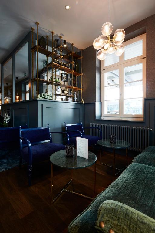 a living room with two beds and two tables at Boutique Hotel Spedition a member of DESIGN HOTELS in Thun