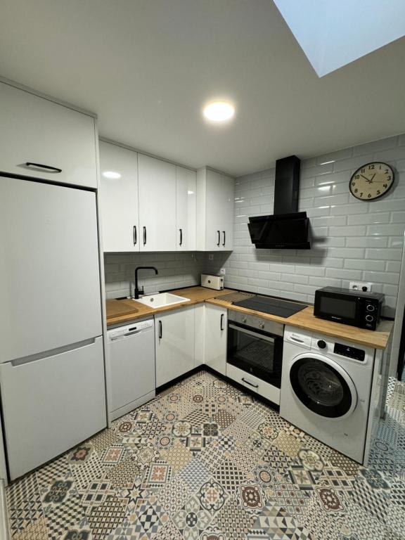 een keuken met witte kasten en een wasmachine bij Apartamento El Alfar in Alhama de Aragón