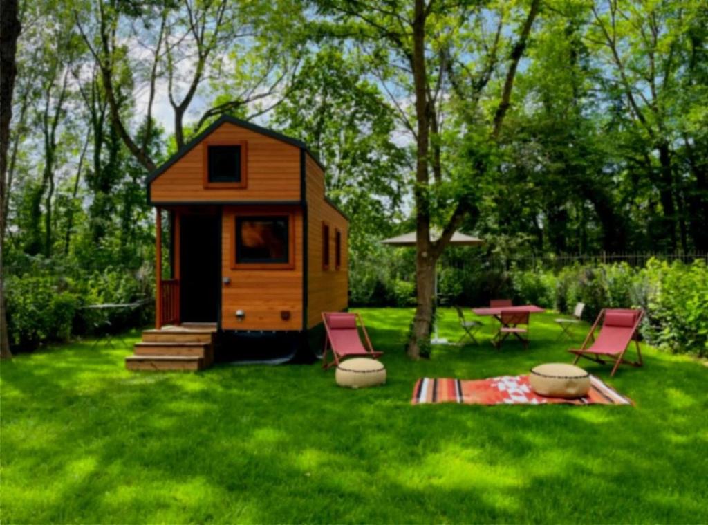 a small house with two chairs and a table in a yard at Cabane 3 étoiles - ccbechc in Neuilly-sur-Marne