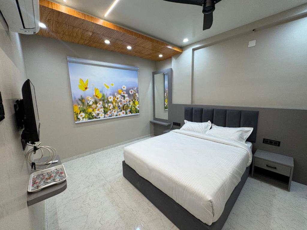 a bedroom with a bed and a television in it at OM Hotel in Sirohi