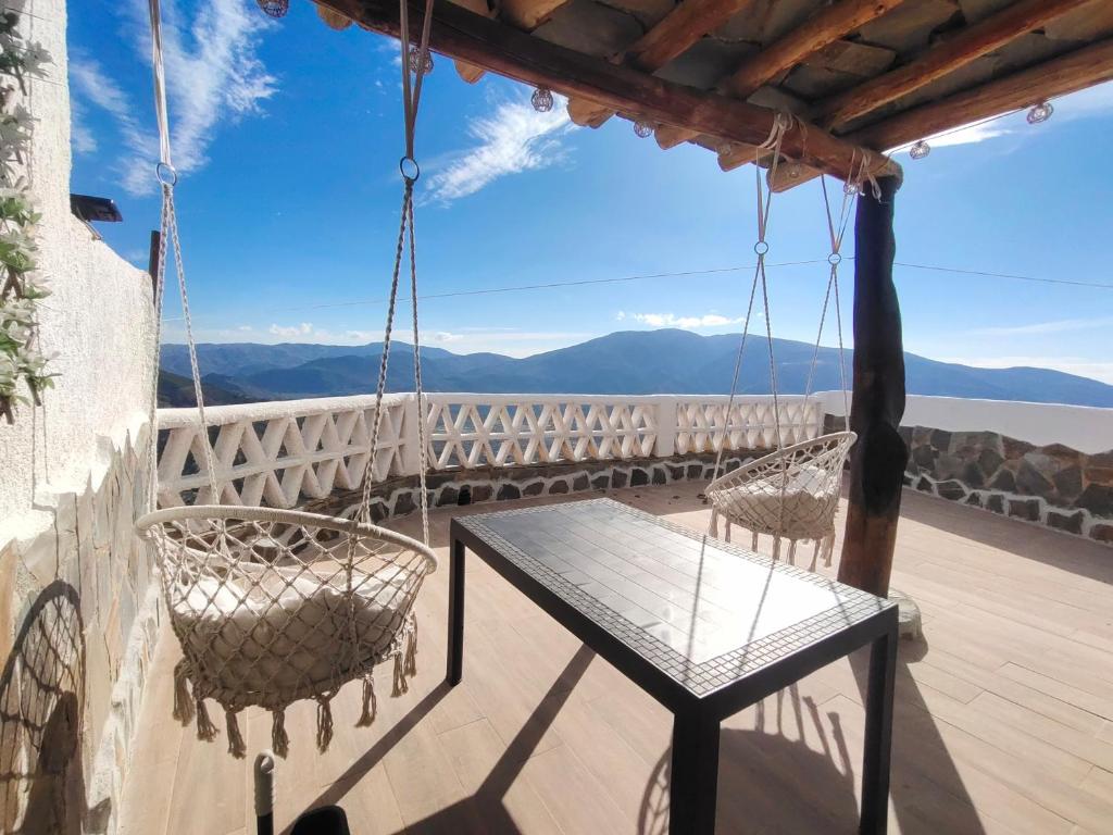 une terrasse avec une table et des chaises sur un balcon dans l'établissement Casa Mirador, à Cáñar