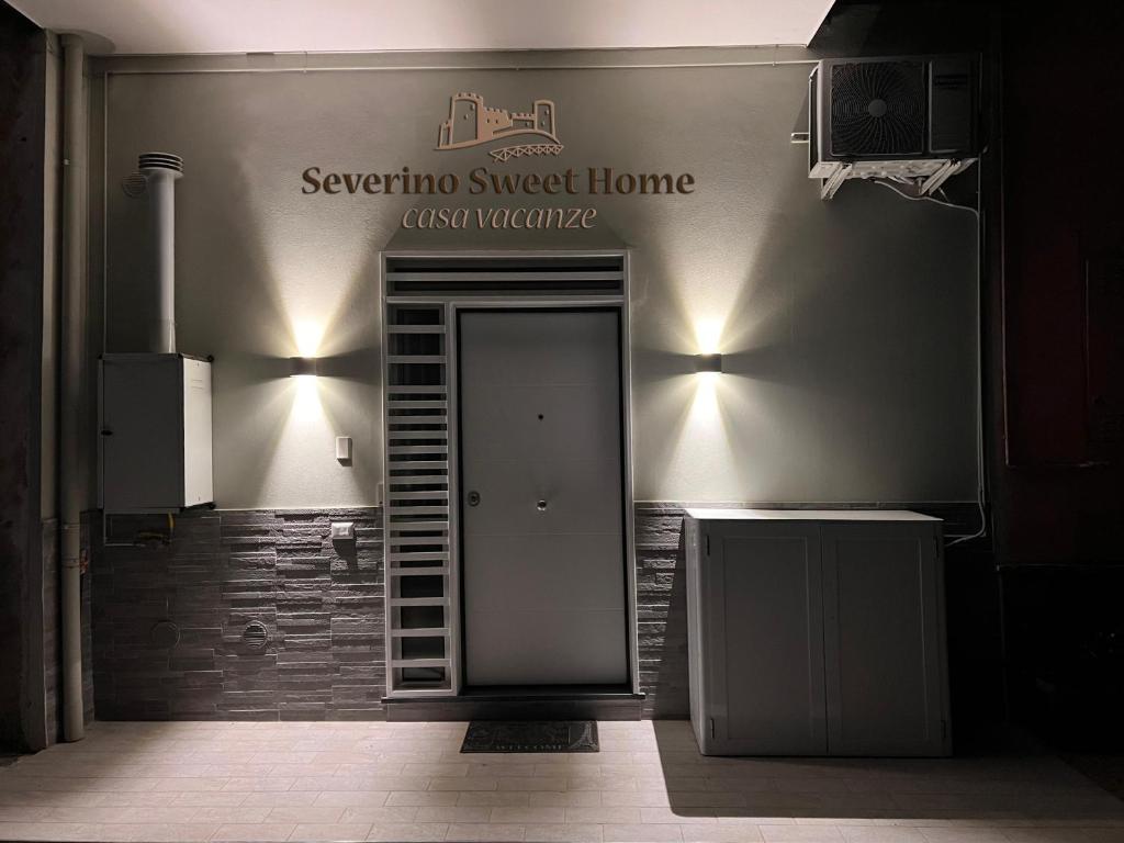 a door in a room with a sign on the wall at Severino Sweet Home Casa Vacanze in Mercato San Severino