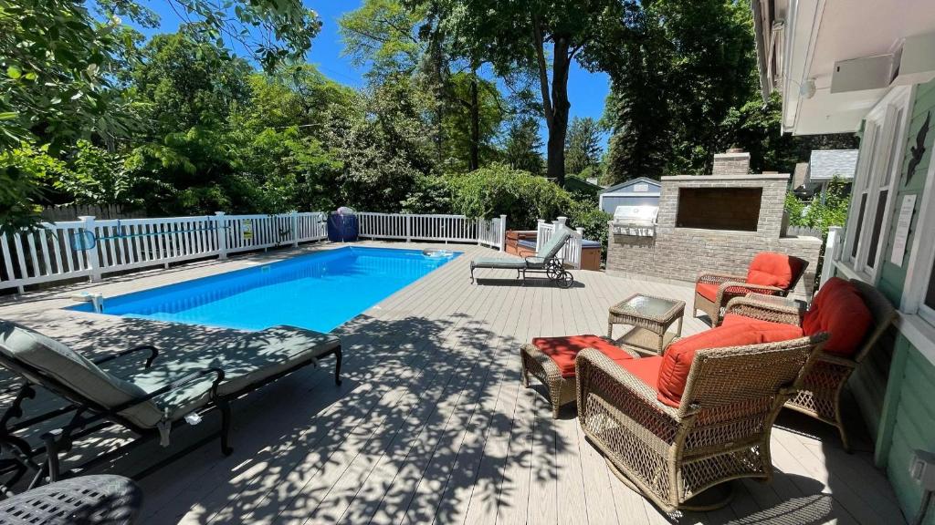 a backyard with a swimming pool and chairs and a table at Sandy Shores in Union Pier