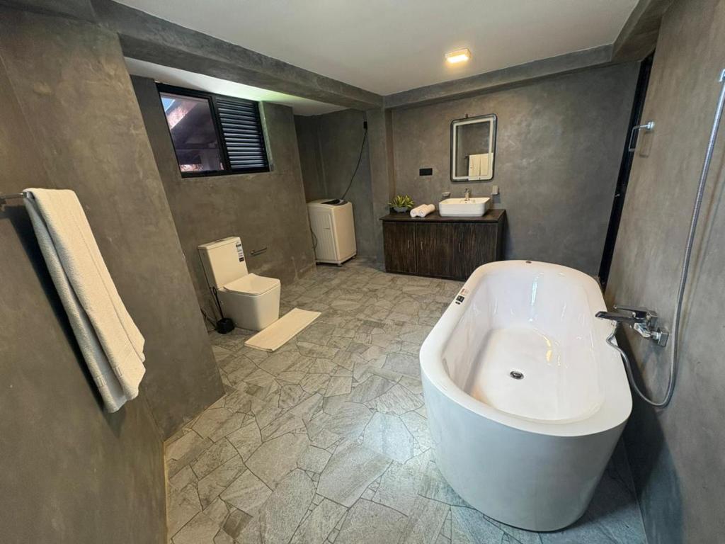 a bathroom with a tub and a sink and a toilet at Villa DEE DEE & Wellness in Galle