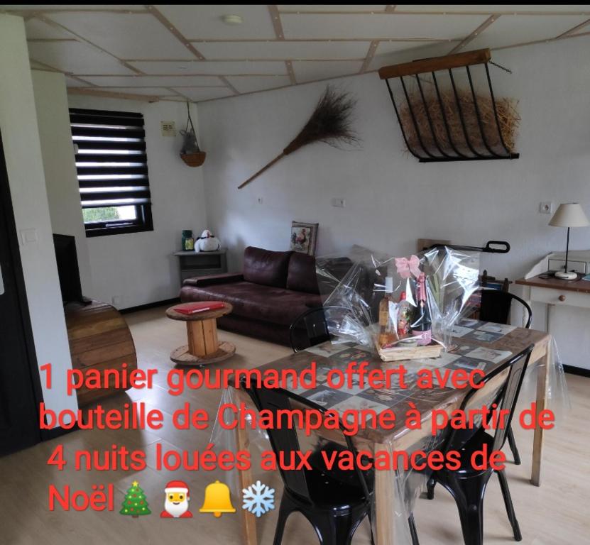 una sala de estar con una mesa con un pájaro en la pared en gite campagne Aupthiesomme au calme entre terre et mer, en Brailly-Cornehotte