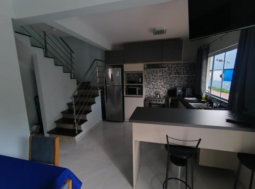 een keuken met aanrecht en een keuken met trap bij Sobrado 3 Condomínio Sobre as Ondas, 4min a pe da Praia in Guaratuba