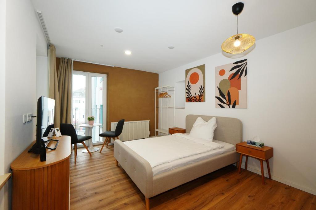 ein Schlafzimmer mit Bett, Schreibtisch und Fernseher in der Unterkunft Livery in Koblenz