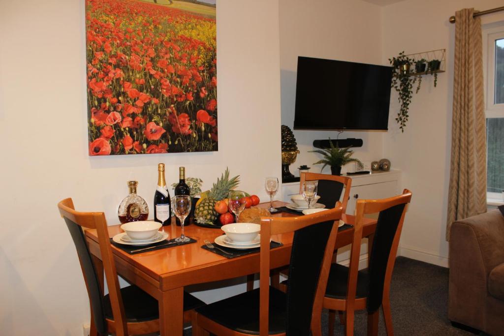 ein Esszimmer mit einem Tisch mit Stühlen und einem Gemälde in der Unterkunft Oliver Wests Beautiful 2 Bedroom Sleeps 4 Apartment in Scarborough