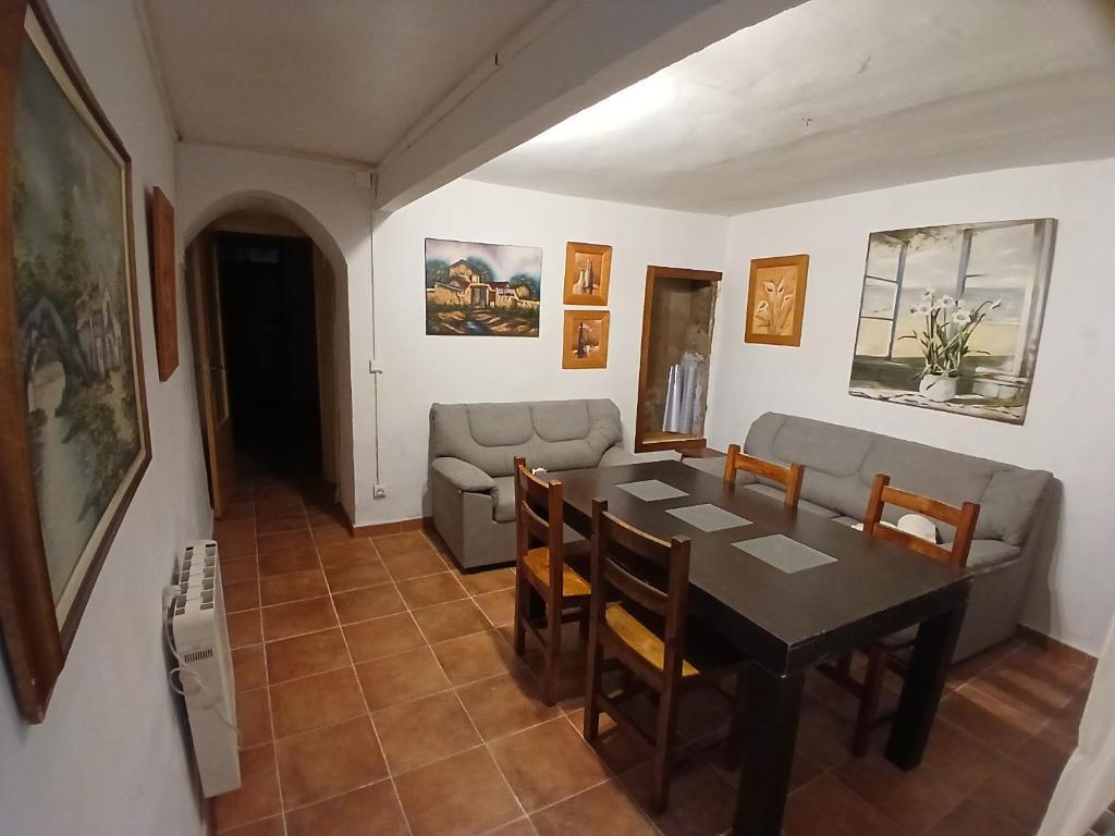 a dining room with a table and a couch at Casa Rural Forcén in Lumpiaque
