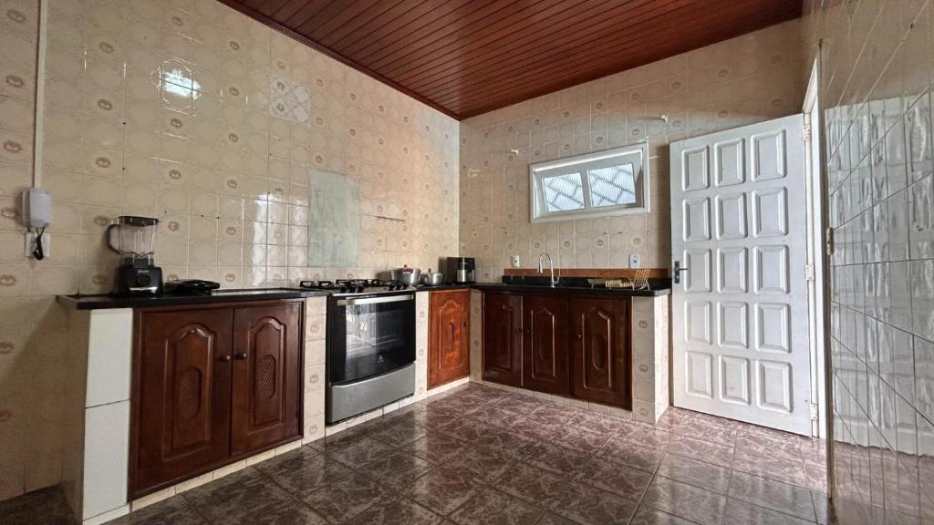 Residencial Paraviana-Casa Piscina في بوا فيستا: مطبخ كبير مع دواليب خشبية ونافذة