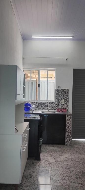 a kitchen with a stove and a counter top at Kitnet montanha magica 3 in São Thomé das Letras
