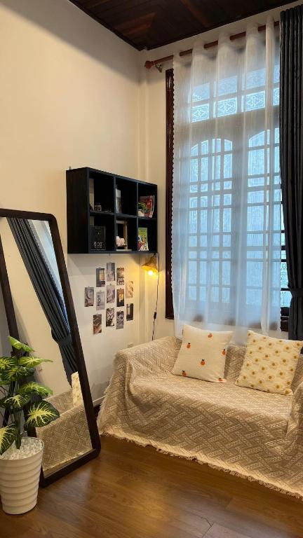 a bedroom with a bed and a mirror and a window at Mật Ong HOUSE in Hue