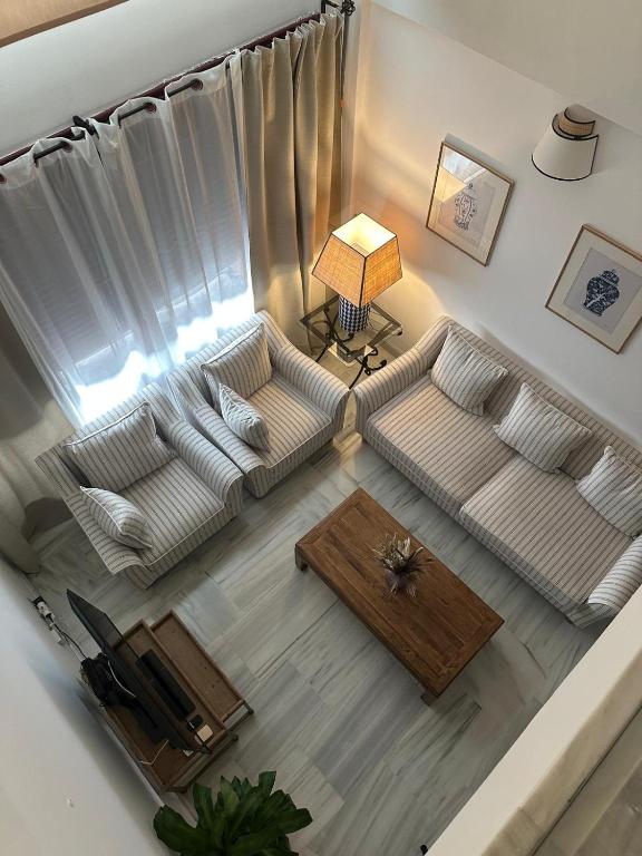 a living room with a white couch and a table at Duplex Botánico Resort in Estepona