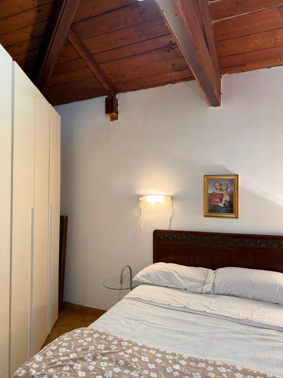 Un dormitorio con una cama y un techo de madera. en Green Cottage, en Casal Palocco