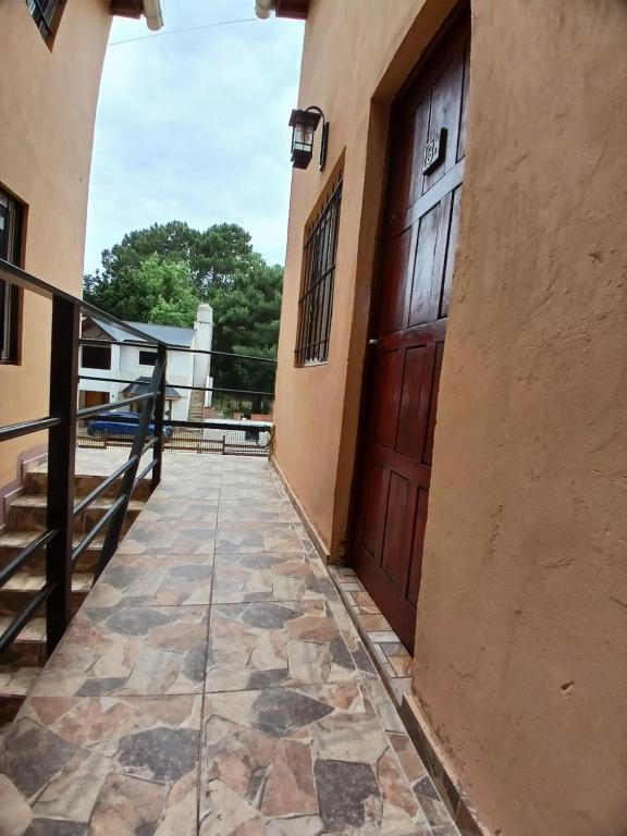 una passerella che conduce a una porta di legno in un edificio di Miniduplex tipo Cabaña a San Bernardo