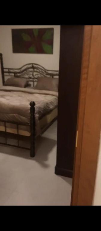 Un dormitorio con una cama y un cuadro en la pared. en شقه مفروشه بالكامل في عمان شارع مكه ضاحيه الأمير راشد, en Amán