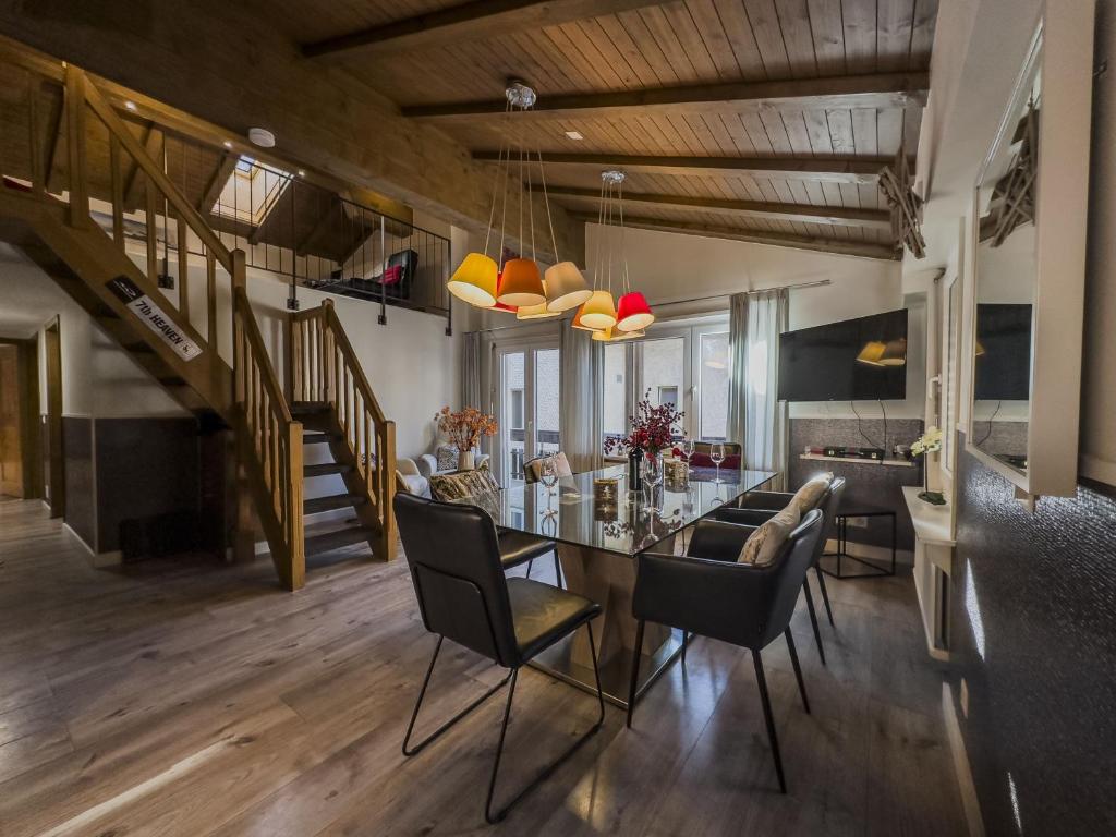 a dining room and living room with a table and chairs at Central & Elegant Apartments,partially with Fireplace, by Zermatt Rental in Zermatt