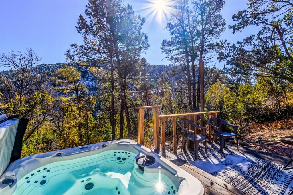 una vasca idromassaggio su un ponte con vista sulla foresta di Mountain Top Cabin with a View - Bear Cabin a Ruidoso
