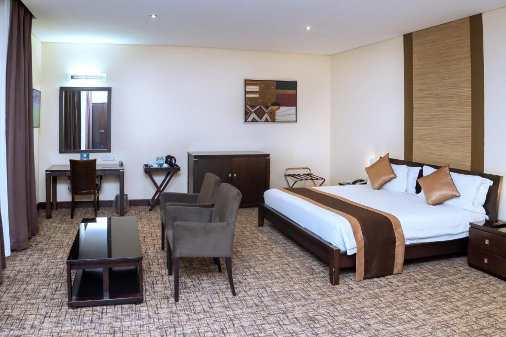una habitación de hotel con una cama y un escritorio en Hotel 33 Kampala, en Kampala