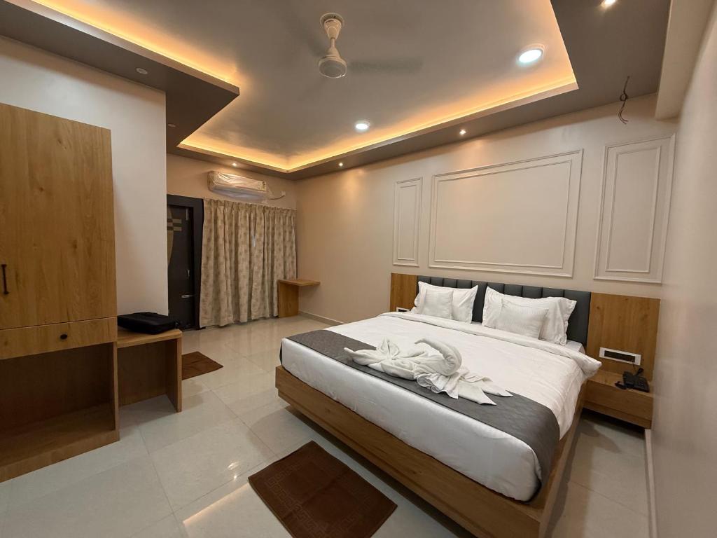 ein Schlafzimmer mit einem großen Bett, auf dem Handtücher liegen in der Unterkunft Hotel The Devaraj in Bhubaneshwar