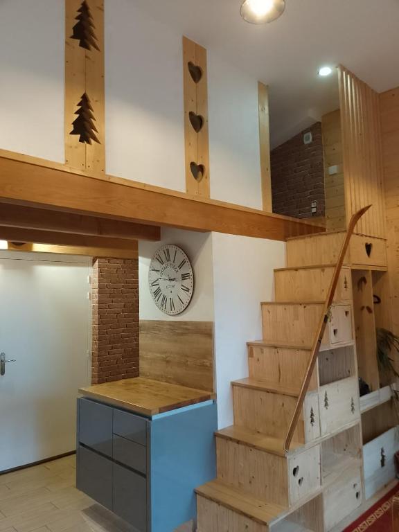 a room with stairs and a clock on the wall at Nid cozy au Lioran in Le Lioran