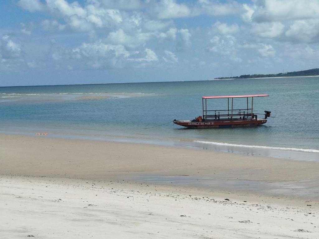 un barco en el agua en la playa en La foca da Croa, en Goiana