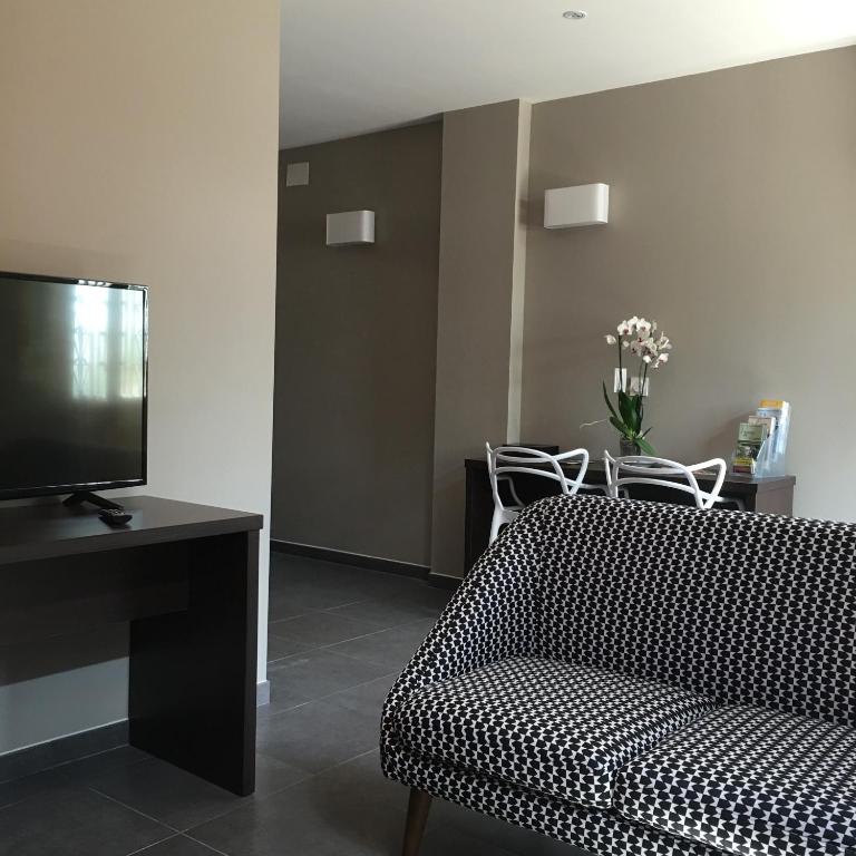 un salon avec un canapé et une télévision à écran plat dans l'établissement Le Brin D'olivier, à Bourg-Saint-Andéol