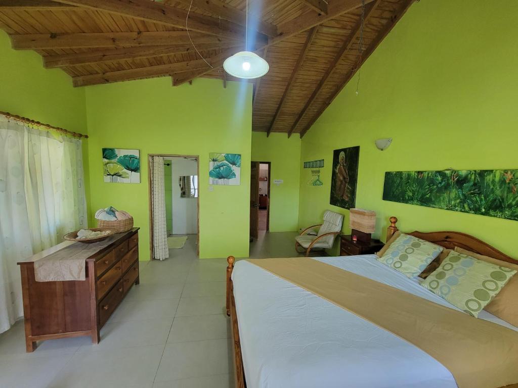 ein Schlafzimmer mit einem großen Bett und grünen Wänden in der Unterkunft A Serene Get Away in Vieux Fort