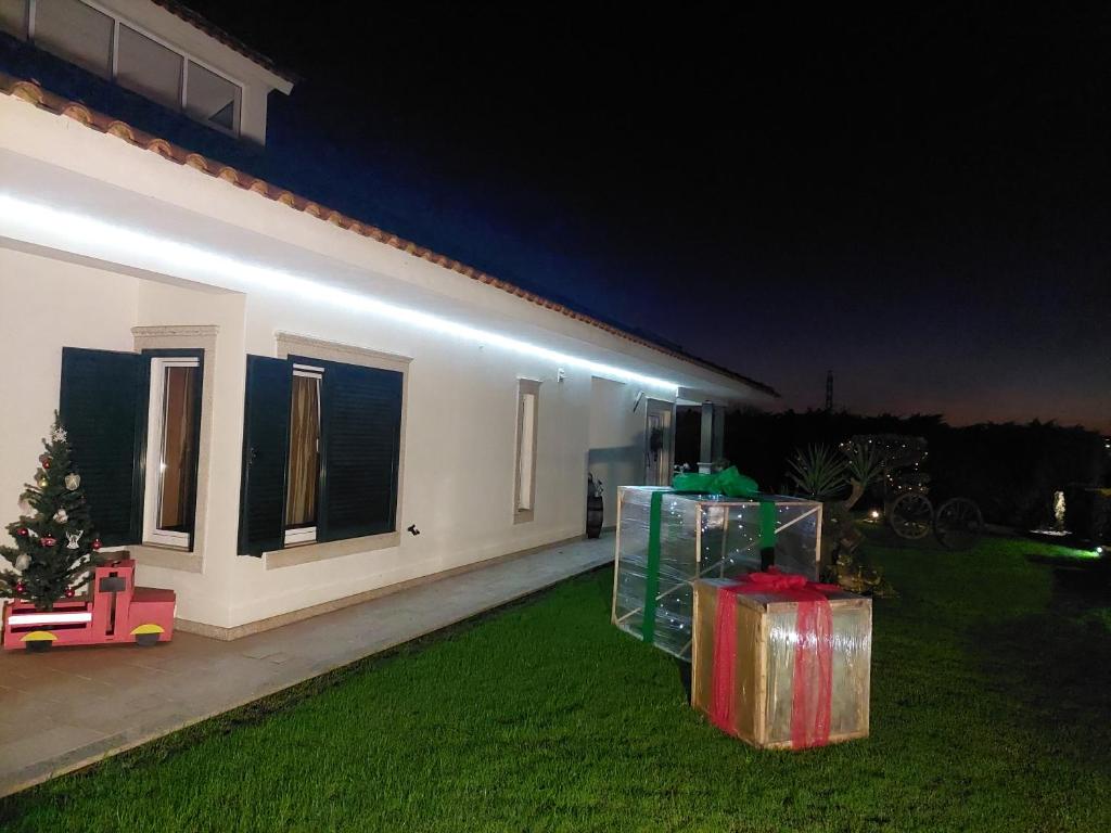 a house with some presents on the lawn at night at TERRENO DAS MIMOSAS in Aveiro
