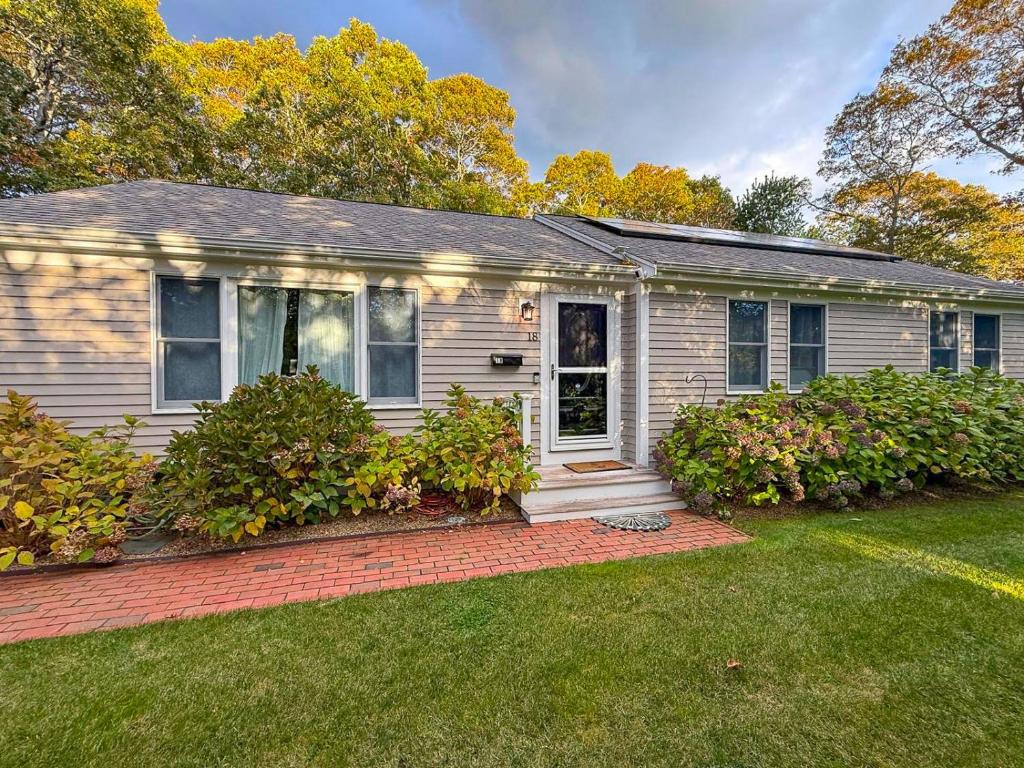 een wit huis met een veranda en een tuin bij Cape Cod Family Getaway Hot Tub Firepit in West Hyannisport