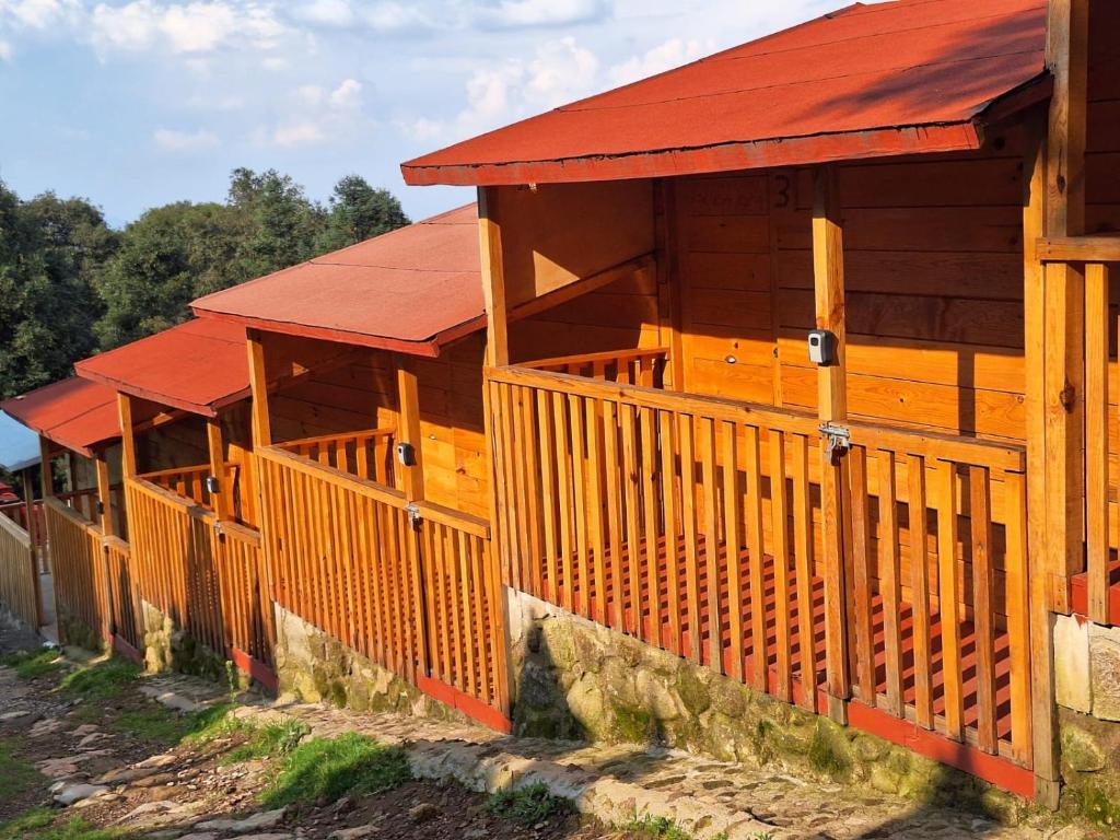 un edificio de madera con techo rojo en La Cabaña, en Tlazala de Fabela