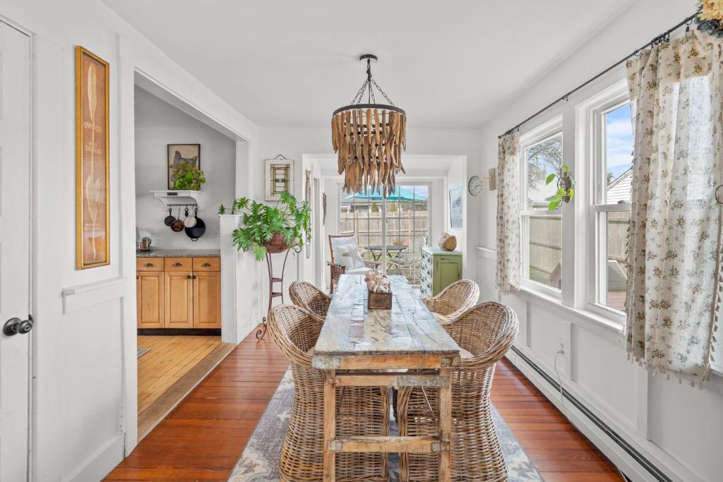een eetkamer met een tafel en rieten stoelen bij Cape Cod Bungalow Walk to Beach Firepit in Hyannis
