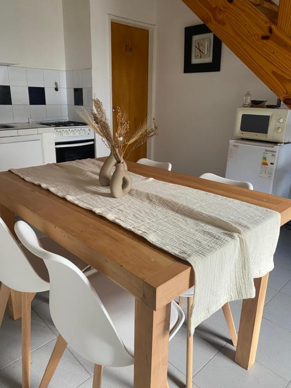 Hogar في ريو جاليجوس: مطبخ مع طاولة خشبية مع كراسي بيضاء