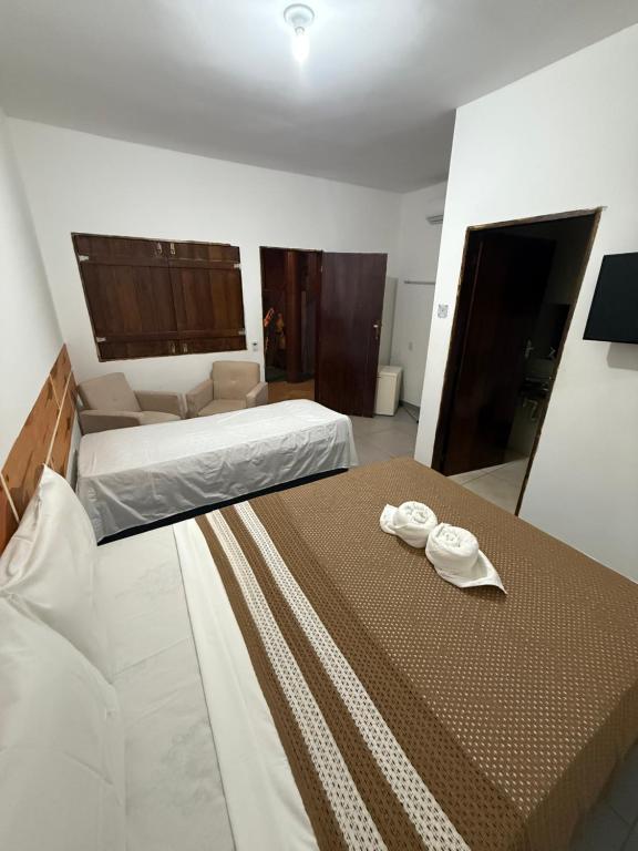 a bedroom with two beds with towels on the bed at Pousada Cantinho de Milagres in São Miguel dos Milagres
