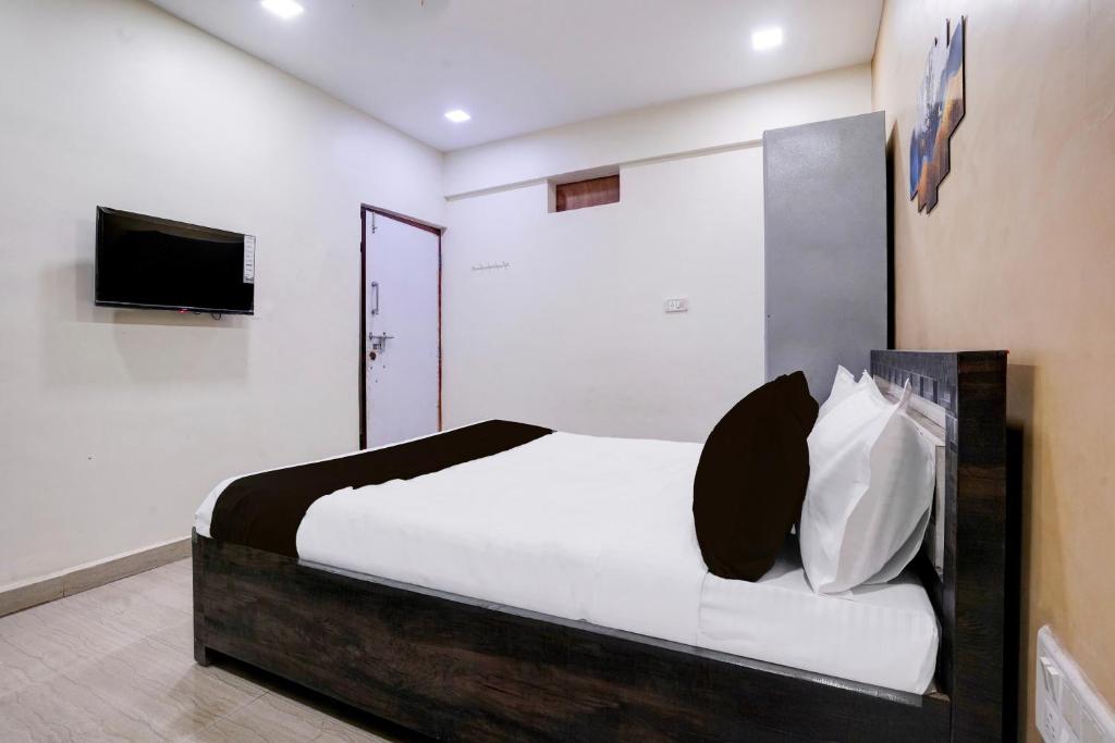 une chambre avec un lit et une télévision au mur dans l'établissement Hotel O Moonlight Residency, à Mumbai