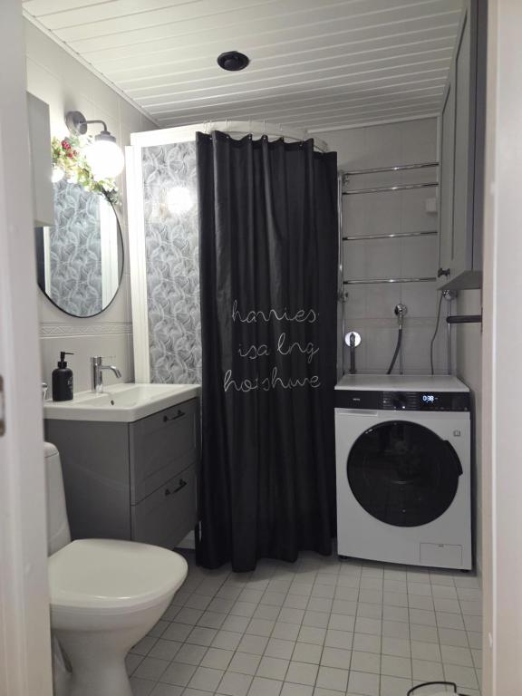 a bathroom with a washing machine in the shower at Arctic Circle Home in Rovaniemi