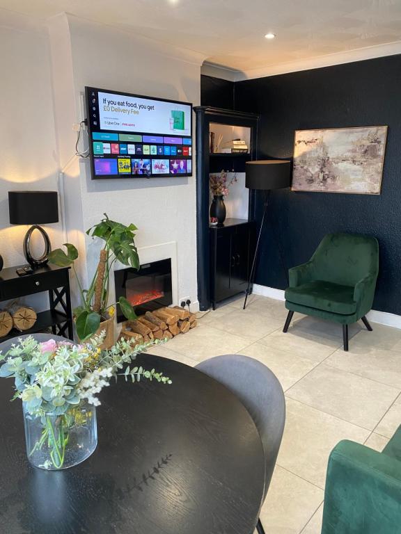 uma sala de estar com uma mesa e uma televisão na parede em Elegant 2 bedroom Flat in Dartford - Kent em Dartford