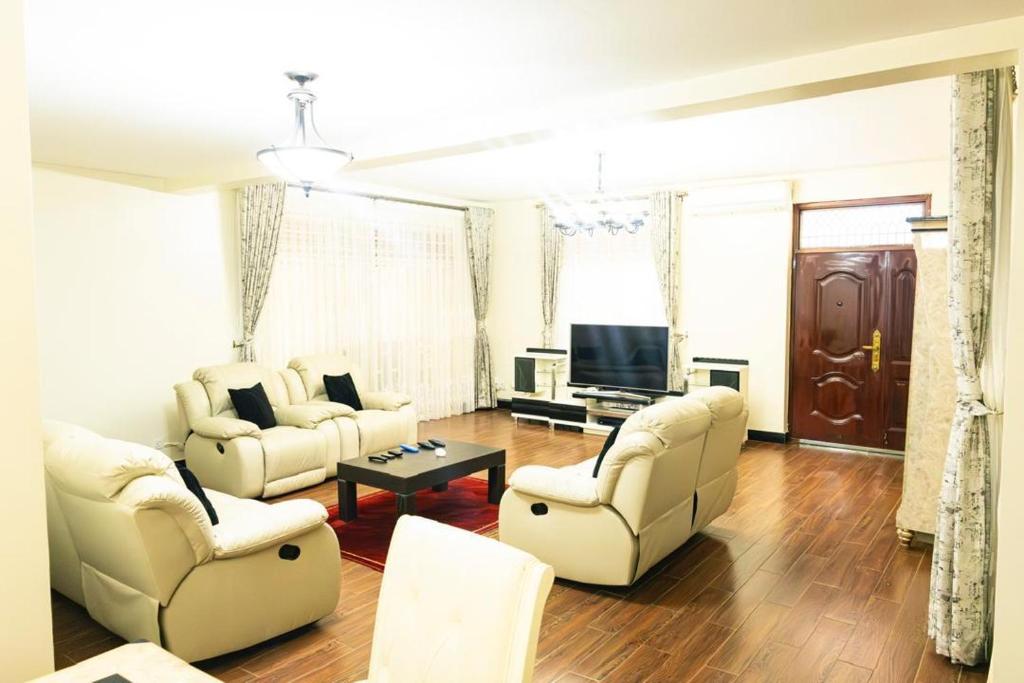 un soggiorno con due divani e una TV di Mirembe Villas Kigo a Kigo