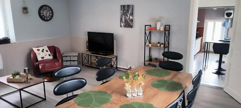 een woonkamer met een tafel, stoelen en een televisie bij La ville haute in Chauvigny