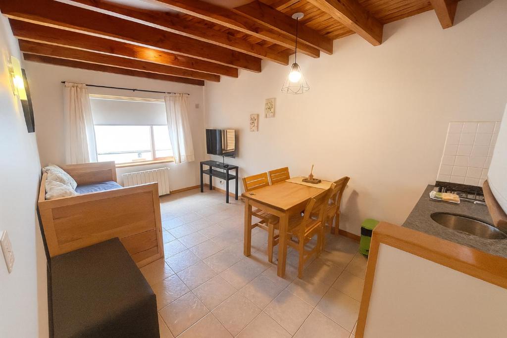 a kitchen with a table and a dining room at Departamento en pleno centro, con Pileta in San Martín de los Andes